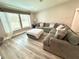 Comfortable living room with large sectional sofa, ottoman, and sunlit windows at 5306 Empire Church Rd, Groveland, FL 34736