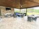 Covered outdoor living area with comfortable seating, a fireplace, and a ceiling fan at 5306 Empire Church Rd, Groveland, FL 34736
