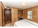 Comfortable bedroom features wood paneling, a bright window and a closet with some storage at 55634 Sam St, Astor, FL 32102