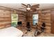 Bedroom with wood paneled walls and multiple windows providing natural light at 55634 Sam St, Astor, FL 32102