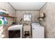 Functional laundry room equipped with a washer, dryer, sink, and storage shelves at 55634 Sam St, Astor, FL 32102