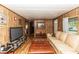 Comfortable living room featuring wood paneled walls and light wood floors at 55634 Sam St, Astor, FL 32102