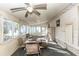 Enclosed sunroom with a ceiling fan, seating area, and multiple windows for natural light at 55634 Sam St, Astor, FL 32102