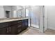 Bathroom with a granite double vanity, a glass enclosed walk-in shower, and wood tile floors at 559 Coronado Cove Rd, New Smyrna Beach, FL 32168
