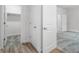 Hallway with wood-look tile floor, carpeted rooms, and white doors at 559 Coronado Cove Rd, New Smyrna Beach, FL 32168