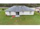 Aerial view showcasing the backyard of the house with green grass and white exterior at 599 S Cedar Ave, Orange City, FL 32763