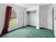 Bright bedroom with green carpet, a window view, and a closet for storage at 599 S Cedar Ave, Orange City, FL 32763