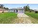 Charming single-story home featuring a gray exterior, attached garage, and well-maintained front lawn at 599 S Cedar Ave, Orange City, FL 32763