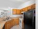 Functional kitchen layout with wooden cabinetry and black appliances at 599 S Cedar Ave, Orange City, FL 32763