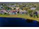 Aerial view displaying the property's screened pool, manicured lawn, and beautiful lakefront setting at 6071 Sabal Hammock Cir, Port Orange, FL 32128