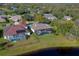 Aerial view highlights screened pools, the lawn, and its close proximity to a lake at 6071 Sabal Hammock Cir, Port Orange, FL 32128