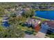 Aerial view of a home showcasing a screened-in pool, landscaping, and its position in a lakeside neighborhood at 6071 Sabal Hammock Cir, Port Orange, FL 32128