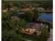 Twilight aerial view of a lakeside home surrounded by lush trees and manicured lawns in a quiet neighborhood at 6071 Sabal Hammock Cir, Port Orange, FL 32128