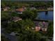 Twilight aerial view of a lakeside home surrounded by lush trees and manicured lawns in a quiet neighborhood at 6071 Sabal Hammock Cir, Port Orange, FL 32128