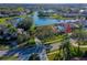 Aerial view showcasing the home with a screened pool, landscaping, and a view of the neighborhood lake at 6071 Sabal Hammock Cir, Port Orange, FL 32128