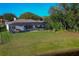 Expansive backyard with well-maintained lawn, screened pool enclosure, and scenic views of the surrounding greenery at 6071 Sabal Hammock Cir, Port Orange, FL 32128