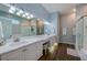 Bright bathroom with dual sinks, wood floor, a glass shower, and a soaking tub at 6071 Sabal Hammock Cir, Port Orange, FL 32128