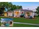 Beautiful single-story home with manicured lawn, mature trees, and a screened-in pool, offering an inviting outdoor oasis at 6071 Sabal Hammock Cir, Port Orange, FL 32128