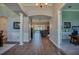 Hallway leading to the living room and office with wood floors and architectural details at 6071 Sabal Hammock Cir, Port Orange, FL 32128