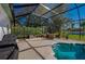 Screened patio with seating area overlooking the pool and lush backyard at 6071 Sabal Hammock Cir, Port Orange, FL 32128