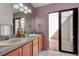 Bright bathroom featuring a double sink vanity, neutral walls, and sliding glass doors to an outdoor patio at 6152 Sequoia Dr, Port Orange, FL 32127