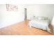 Clean bedroom with light wood floors, white walls and ceilings, a bed, and view into another room at 6152 Sequoia Dr, Port Orange, FL 32127