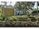 Landscaped entrance to Riverwood Plantation features a stone wall and sign, welcoming residents and visitors alike at 6152 Sequoia Dr, Port Orange, FL 32127