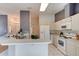 Bright kitchen featuring white cabinetry, appliances, and a breakfast bar open to the adjacent space at 6152 Sequoia Dr, Port Orange, FL 32127