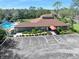 Community clubhouse featuring a pool, mature trees, and ample parking at 6157 Sequoia Dr, Port Orange, FL 32127