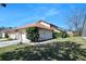 This is a view of the home and garage with manicured lawn and mature landscaping, creating a welcoming curb appeal at 6157 Sequoia Dr, Port Orange, FL 32127
