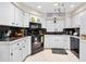 Bright kitchen with white cabinets, black appliances, and dark countertops at 6157 Sequoia Dr, Port Orange, FL 32127