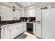 Classic kitchen with white cabinetry, black appliances, and modern fixtures at 6157 Sequoia Dr, Port Orange, FL 32127
