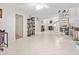 Open-concept space with light tile flooring and spiral staircase at 6157 Sequoia Dr, Port Orange, FL 32127