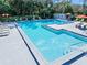 Community pool with lounge chairs and sun umbrellas surrounded by lush landscaping at 6157 Sequoia Dr, Port Orange, FL 32127