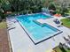 Aerial view of the pool and deck with tables and umbrellas surrounded by trees at 6157 Sequoia Dr, Port Orange, FL 32127
