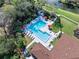 Community pool and patio with lounge chairs and shade umbrellas surrounded by mature landscaping at 6157 Sequoia Dr, Port Orange, FL 32127