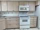Well-equipped kitchen with light wood cabinets, white appliances, and ample countertop space for cooking and entertaining at 625 N Halifax Ave # 15, Daytona Beach, FL 32118