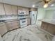 Spacious kitchen featuring light wood cabinetry, white appliances, and a stylish marble-patterned tile floor at 625 N Halifax Ave # 15, Daytona Beach, FL 32118