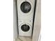 A stacked white Affinity washer and dryer sit atop a tile floor in the laundry area at 625 N Halifax Ave # 15, Daytona Beach, FL 32118