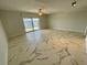 Bright living room with a patio door leading to a waterfront view features modern tile floors and a ceiling fan at 625 N Halifax Ave # 15, Daytona Beach, FL 32118