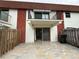 A view of the rear patio area including tiled patio with sliding glass doors and balcony above at 625 N Halifax Ave # 15, Daytona Beach, FL 32118