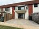A view of the rear patio area including tiled patio with sliding glass doors and balcony above at 625 N Halifax Ave # 15, Daytona Beach, FL 32118