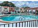 Community pool with clear water surrounded by lounge chairs and a fence at 625 N Halifax Ave # 15, Daytona Beach, FL 32118