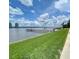 Expansive waterfront view featuring a wooden pier, lush green lawn, and serene water under a partly cloudy sky at 625 N Halifax Ave # 15, Daytona Beach, FL 32118
