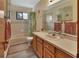 Traditional bathroom featuring wood cabinetry, neutral tile, vanity and shower/tub at 749 E Wisconsin Ave, Orange City, FL 32763