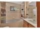 Bright bathroom with a tub and shower combo, window, vanity and neutral tile at 749 E Wisconsin Ave, Orange City, FL 32763