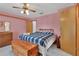 This cozy bedroom features soft pink walls, ceiling fan and an ensuite bathroom at 749 E Wisconsin Ave, Orange City, FL 32763