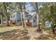 Two-story home featuring light blue siding and red brick foundation and surrounded by mature trees at 749 E Wisconsin Ave, Orange City, FL 32763