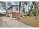 Two-story home featuring light blue siding and red brick foundation with large driveway at 749 E Wisconsin Ave, Orange City, FL 32763