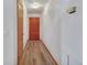 Hallway with wood-look floors, a wooden door, and white walls at 749 E Wisconsin Ave, Orange City, FL 32763